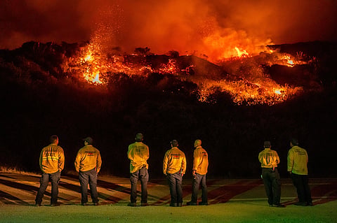 Firefighters watch as a wildfire called the Plaskett Fire burns towards Highway 1 on Friday, Aug. 28, 2026, in Big Sur, Calif. 