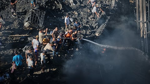 Palestinians try to extinguish a fire in the rubble of a destroyed building following an Israeli airstrike in Gaza City, Monday, Aug. 24, 2026.