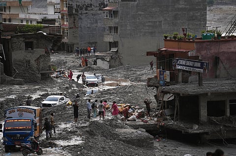 People salvage their belongings from a building damaged by flash flooding in Nuwakot district of Nepal, Tuesday, Sept. 1, 2026