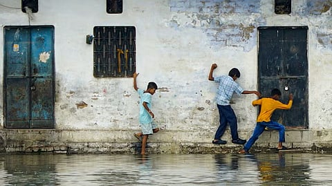  Varanasi: Children walk alongside a waterlogged road at Chowkaghat area after the rise of water level of Varuna river, in Varanasi, Uttar Pradesh, Tuesday, Sept. 1, 2026.