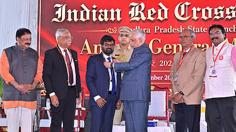 Governor S Abdul Nazeer presents the IRCS Awards to Krishna Collector DK Balaji in Vijayawada on Tuesday.