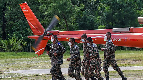 Nepal Army personnel return after taking a person injured in flash flooding aboard a helicopter for evacuation in Nepal's Nuwakot district, Wednesday, Sept. 2, 2026