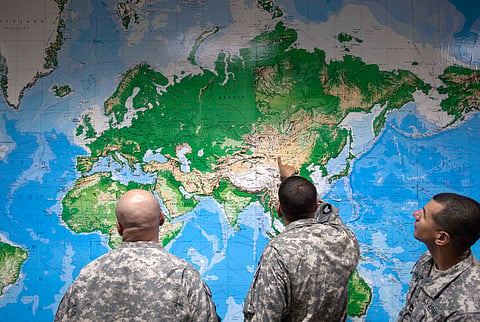  Soldiers look at a world map as they wait to board a flight in Manas, Kyrgyzstan, on the way home after completing a deployment in Afghanistan, Thursday, Aug. 11, 2011. 