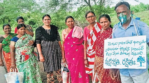 A 45-year-old electrician, Kontu Sambaiah, plants saplings with other residents of Enkoor in Khammam district