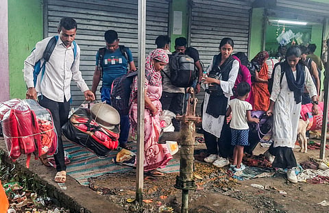 Men, women and children with luggage wait at the BSF checkpost at Hakimpur border outpost, North 24 Parganas, on the road to Bangladesh
