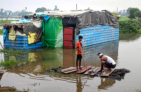 Patna: A man and a child prepare a makeshift boat to move through a flood-affected area inundated with the swollen Punpun river, in Patna, Bihar, Sunday, Sept. 6, 2026. 