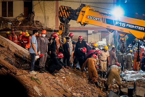 Police, NDRF, fire department officials conduct a rescue operation after a 50-year-old five-storey building housing a boys' hostel collapsed in a congested bylane in Satya Niketan near Delhi University's south campus, Sunday, Sept. 6, 2026. 