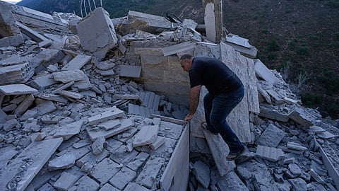 A man searches between the rubble of a destroyed house that was hit by an Israeli airstrike in Arab Salim village, southern Lebanon, Sunday, Sept. 6, 2026.