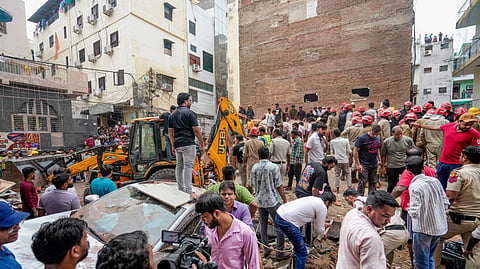 People gather on site after a five-storey building collapsed at Satya Niketan area, in New Delhi, Sunday, Sept. 6, 2026. 