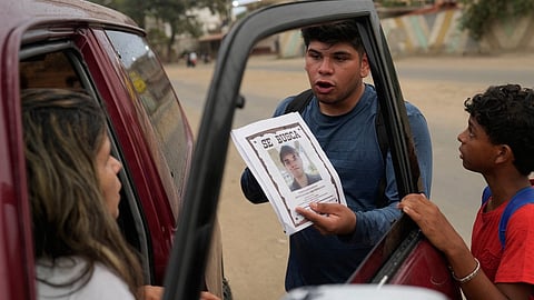 Pedro Gomez asks people about his cousin, Andres Molina, who has been missing since the earthquakes, in La Guaira, Venezuela, Saturday, Aug. 22, 2026.