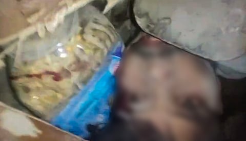 A person trapped under debris after a 50-year-old five-storey building housing a boys' hostel collapsed in a congested bylane in Satya Niketan near Delhi University's south campus, Sunday, Sept. 6, 2026. 