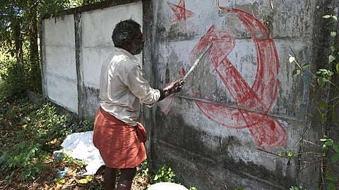 An LDF worker removes the hammer, sickle and star symbol of CPI(M) painted in the aftermath of Kerala Assembly elections earlier this year in Thiruvananthapuram