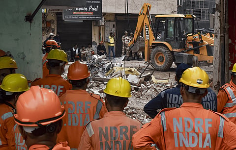 National Disaster Response Force (NDRF) personnel along with a sniffer dog during rescue operations following the collapse of a multi-storey building housing a PG, at Satya Niketan, in New Delhi, Monday, Sept. 7, 2026. 