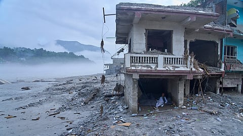 A survivor rests inside a house damaged by flash floods on the bank of Trishuli river in Devighat, Nuwakot district, Nepal, Monday, Sept. 7, 2026.