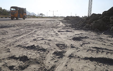 Dust rises from M-sand waste dumped along the roadside of the Western Ring Road (WRR) near Sugunapuram in Coimbatore on Tuesday