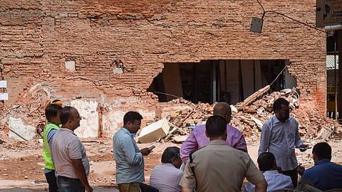 Police officials and people gather at the site during a rescue operation following the collapse of a multi-storey building housing a PG accommodation at Satya Niketan, in New Delhi, Tuesday, Sept. 8, 2026. 
