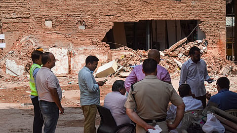 Police officials and people gather at the site during a rescue operation following the collapse of a multi-storey building housing a PG accommodation at Satya Niketan, in New Delhi, Tuesday, Sept. 8, 2026.
