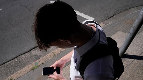 A teenage boy uses his phone in Sydney, Nov. 8, 2024. 