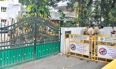 Police personnel stand guard outside the official residence of PWD Minister Satish Jarkiholi during the Enforcement Directorate raid in Bengaluru on Wednesday.
