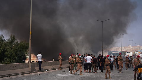 Syrian security forces and others gather as smoke rises after an explosion at what state media said was a weapons depot in the Burj al-Nimra area near Sarmada, in Idlib province, Syria, Wednesday, Sept. 9, 2026.