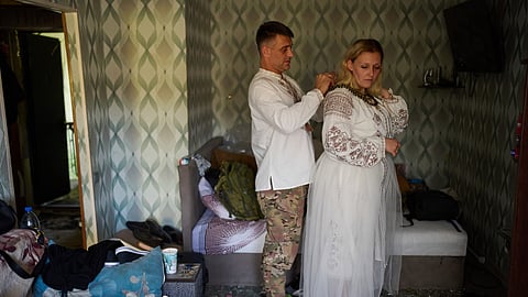Liudmyla Ryzhak, right, and her fiancee Leonid Ryzhak get ready for their wedding ceremony in their damaged apartment, following a Russian missile and drone attack in Kyiv, Ukraine, Tuesday, Sept. 8, 2026.