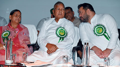 In this file photo from June 19, 2025, Rashtriya Janata Dal (RJD) Chief Lalu Prasad Yadav (C) with party leaders Rabri Devi (L) and Tejashwi Yadav (R) during the RJD State Council Meeting, at Gyan Bhawan in Patna.