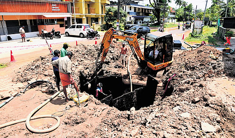 Contract workers repair a drinking water pipeline that burst after a heavy vehicle passed through Pipeline Road in the second ward of Thrikkakara municipality 
