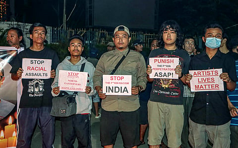 People hold placards during a candle march for Manipur based guitarist Chongtham Vikram Singh who was allegedly beaten to death in Southeast Delhi, in Imphal on Tuesday.