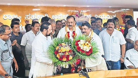 Cooperation Minister Laxman Savadi greets newly elected Apex Bank president and MLC S Ravi and vice-president Sharanagouda Patil Bayyapur on Thursday 