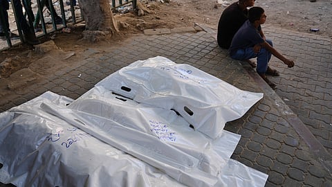 Palestinians sit beside the bodies of members of the Ahmed family, including the parents and their two children, who were killed in an Israeli army strike, at Shifa Hospital in Gaza City, Thursday, Sept. 10, 2026. 