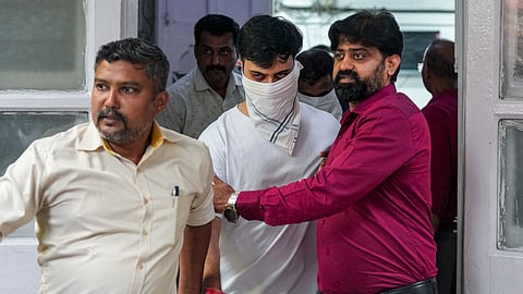 Police officials arrest Rohan Parikh, white mask, a 24-year-old man, after he claimed to be a PMO official and allegedly forced entry at a shopping mall in Bandra-Kurla Complex (BKC) while carrying a firearm in Mumbai, Tuesday, Sept. 8, 2026.