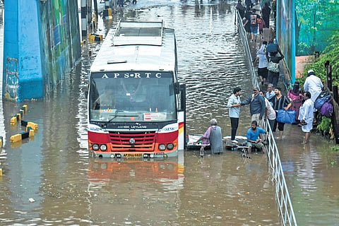 Tricycles deployed to enable passengers to alight from an RTC bus, which got stuck in water after a downpour near PNBS in Vijayawada