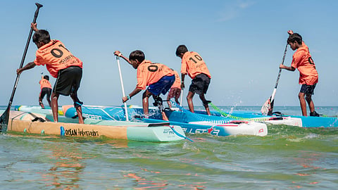 Young trainees practise stand-up paddleboarding during a training session in the waters off Ramanathapuram coast 