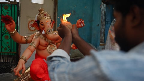 A devotee performs aarti before carrying an idol of Lord Ganesha from a workshop on the eve of the Ganesh festival at Dhoolpet in Hyderabad on Sunday. 