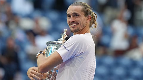 Alexander Zverev, of Germany, poses with the trophy after he won the men's singles final of the U.S. Open tennis championships against Ben Shelton, of the United States, Sunday, Sept. 13, 2026, in New York. 