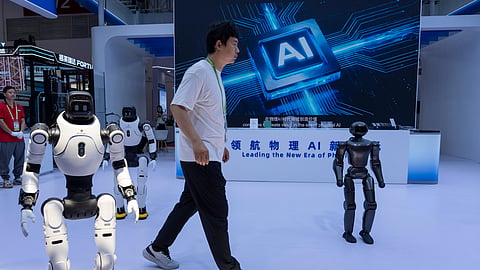 A worker passes by robots from Chinese company Lens at the China International Supply Chain Expo in Beijing on Monday, June 22, 2026.