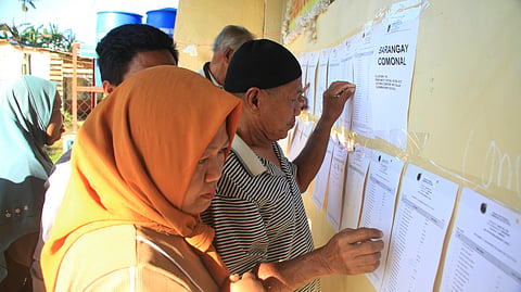 Muslim residents check their names at a voting center during the Bangsamoro Autonomous Region of Muslim Mindanao (BARMM) elections at a school in Saguiaran, Lanao del Sur province, southern Philippines, Monday Sept. 14, 2026.