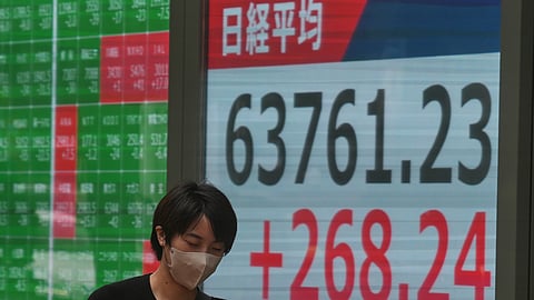 A person walks in front of an electronic stock board showing Japan's Nikkei index at a securities firm Tuesday, Sept. 15, 2026, in Tokyo.