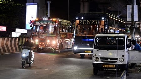 Omni buses waiting to pick up passengers along a busy stretch at Guindy.