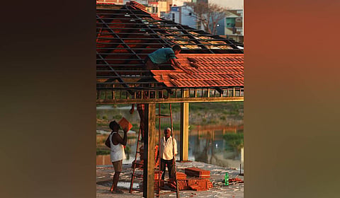 Workers install terracotta roof tiles on a viewpoint being constructed as part of the rejuvenation of Sunnam Cheruvu by the HYDRAA, which is transforming the neglected water body into a 30-acre freshwater lake and public space in Hyderabad.