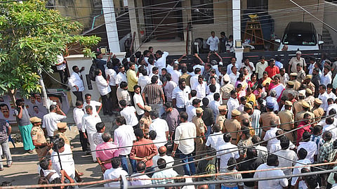 DMK cadres gather in front of former minister Anbil Mahesh Poyyamozhi's residence in Tennur, Tiruchy on Wednesday, during a CCB search.