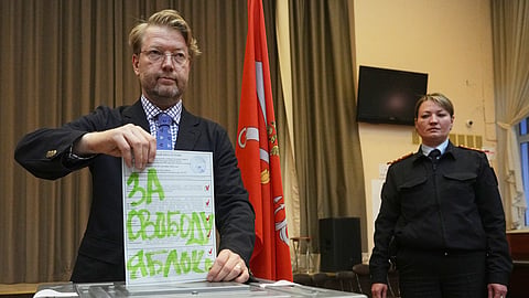 Yabloko party leader Nikolai Rybakov casts a ballot with a writing in Russian reading "For freedom" during the parliamentary election in St. Petersburg, Russia, Sunday, Sept. 20, 2026