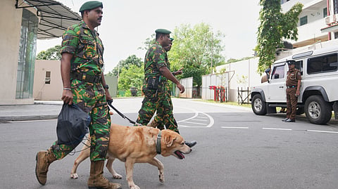 Police commandos patrol with a sniffer dog at the High Court complex ahead of a verdict related to the 2019 Easter bombings in Colombo, Sri Lanka, Tuesday, Sept. 22, 2026.