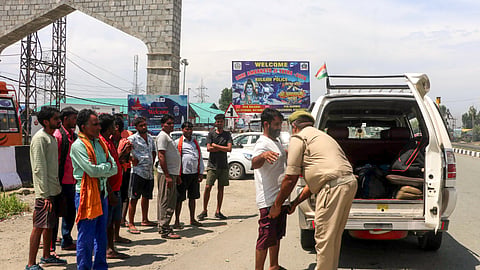 In this file photo from Aug. 14, 2026, a police official checks commuters on the Jammu-Srinagar National Highway as security heightens on the eve of the 80th Independence Day, in Anantnag. 