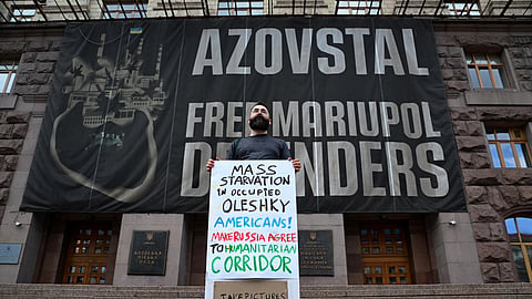 A man holds a placard reading "Mass starvation in occupied Oleshky, in Kyiv, Sept. 20, 2026.