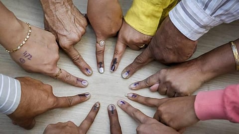 Voters pose for a photo showing their fingers marked with indelible ink after casting their votes during elections. 