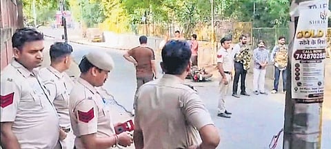 Police personnel stand at a sealed area near the Kalkaji Mandir on Tuesday.