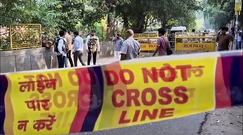 Police personnel and people stand at a sealed area, at Aastha Kunj Park where the minor was gand raped. 