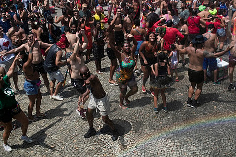 Revelers cool off with the help of spray truck showering water into the crowd of partiers amid the extreme heat, Feb. 15, 2025.