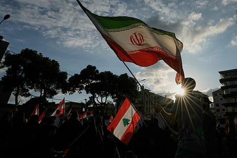 A Hezbollah supporter waves an Iranian flag during a protest against the continued ban on flights between Iran and Lebanon in the southern Beirut suburb of Haret Hreik, Lebanon, Tuesday, Sept. 22, 2026. 